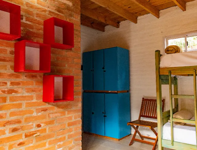 Habitación con lockers celestes y estantes rojos